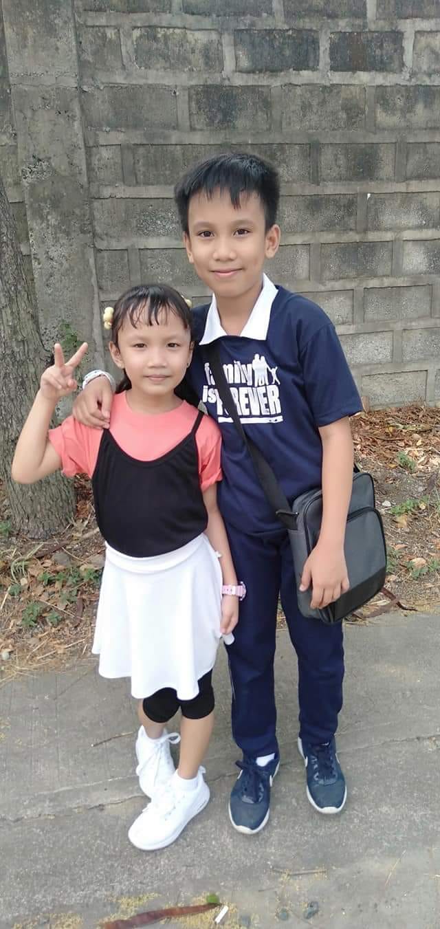 A young boy with his little sister taking a picture together