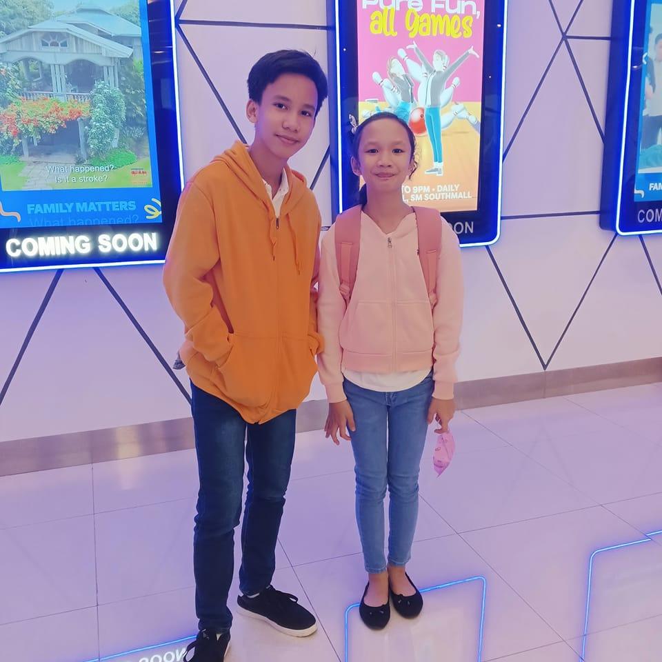 A young boy with his little sister taking a picture together