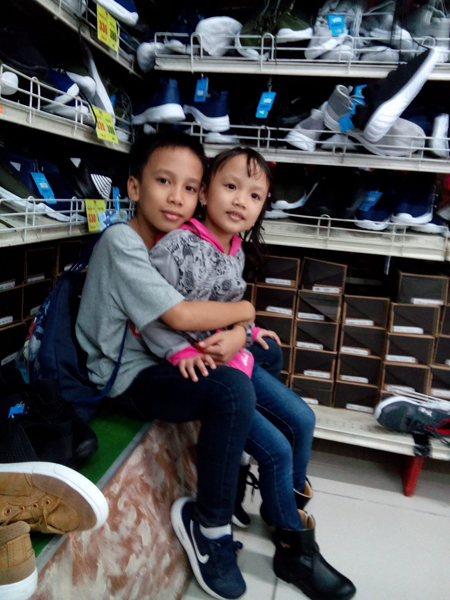 A young boy with his little sister taking a picture together