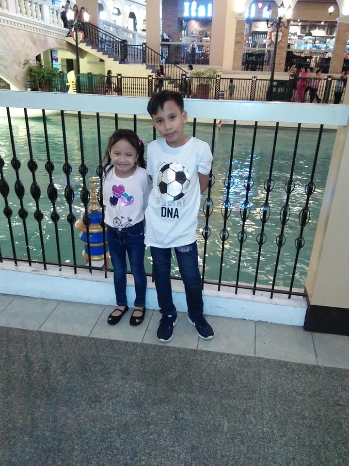 A young boy with his little sister taking a picture together