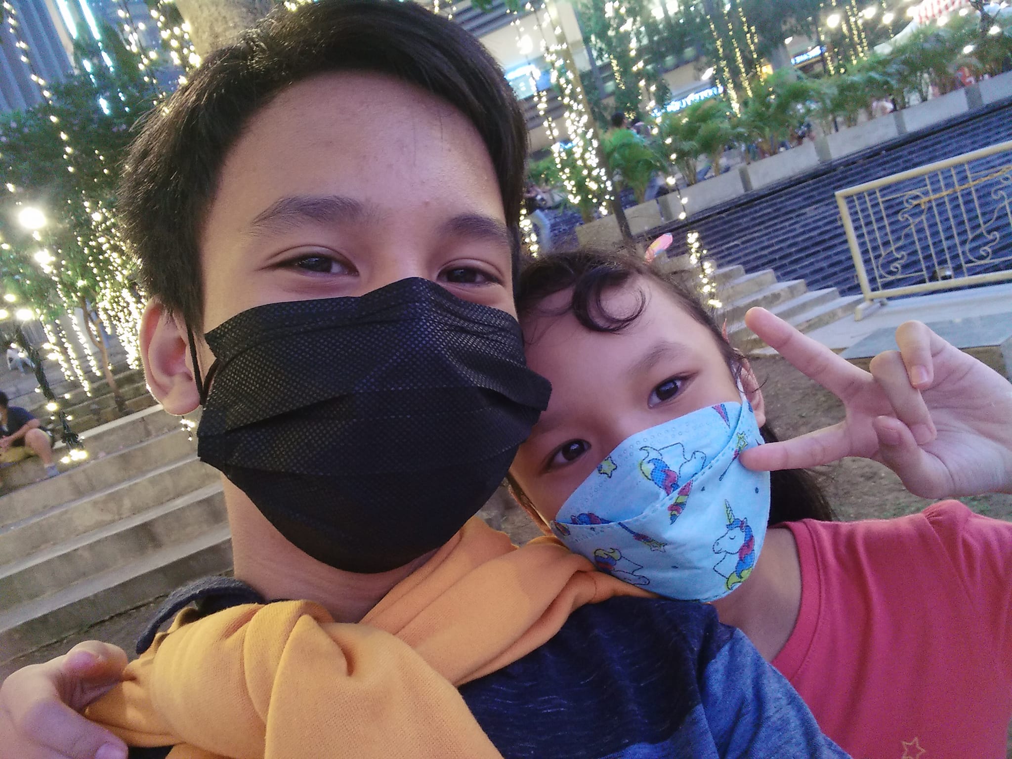 A young boy with his little sister taking a picture together